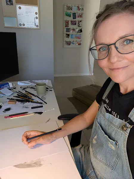Image of Shandy drawing at desk.